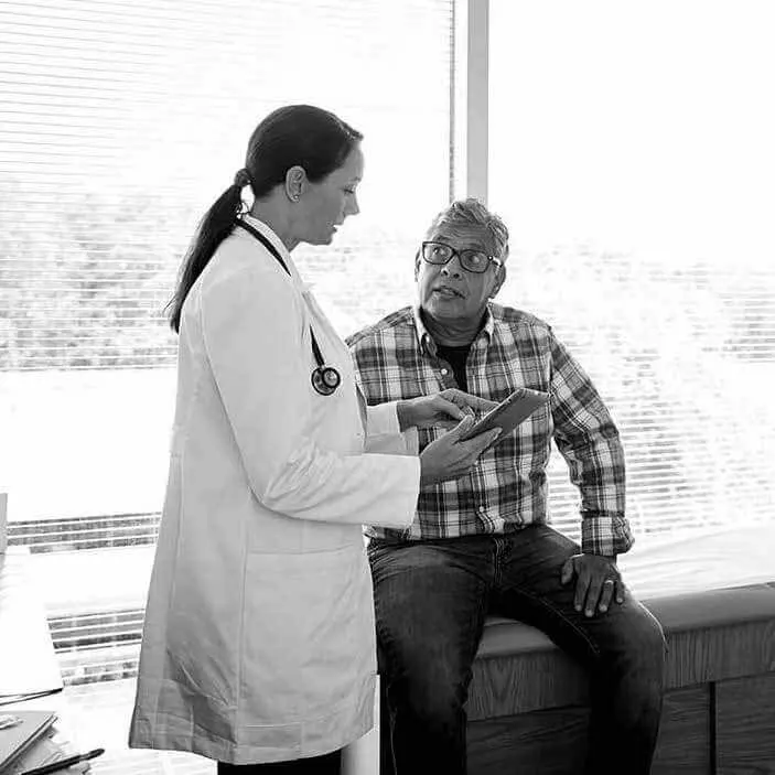 Man talking to his doctor about testing for Alzheimer's disease.