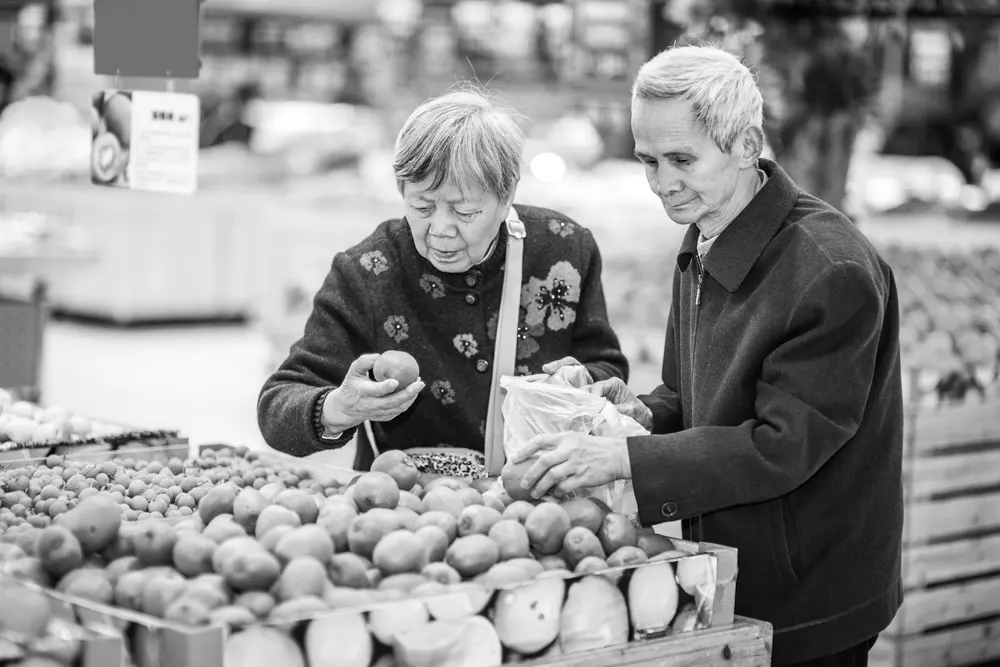 Una pareja de adultos mayores  en el supermercado eligiendo alimentos saludables para mejorar la salud del cerebro