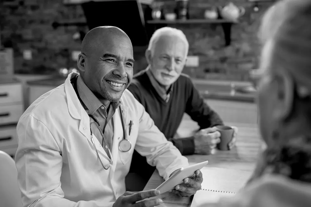 Un médico toma un café con una pareja mayor para hablar sobre cómo están acabando con el estigma que rodea al alzhéimer
