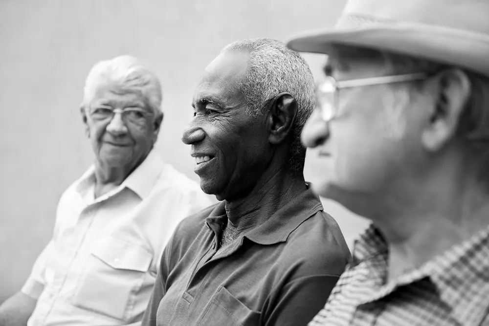 Three older men sitting together discussing the early signs and symtoms of Mild Cognitive Impairment