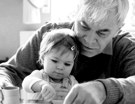 Man helping grand daughter draw